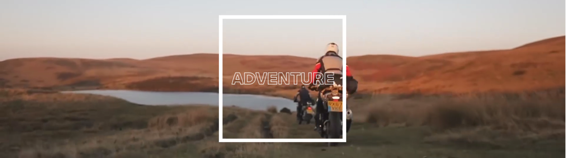 Ein Panoramafoto von hinten, das eine Gruppe von drei Motorradfahrern zeigt, die im Abendlicht eine trockene, grasbewachsene Landschaft durchqueren. Im Hintergrund sind sanfte Hügel und ein kleiner See zu sehen. Der Himmel ist orange-rosa. Über dem Bild ist ein breiter, weißer Rahmen mit dem Wort „ADVENTURE“ in Großbuchstaben.