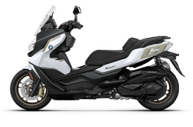  Ein großer, weißer und schwarzer Maxi-Scooter von BMW. Er steht schräg von der Seite fotografiert vor einem weißen Hintergrund. Der Roller hat eine große Windschutzscheibe, goldene Felgen und goldene Akzente auf der Verkleidung.