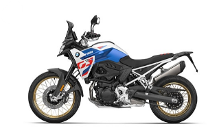  Ein sportliches Adventure-Motorrad von BMW, schräg von der Seite fotografiert vor einem weißen Hintergrund. Das Motorrad ist weiß, blau und rot, in den klassischen BMW M-Farben. Es hat goldene Speichenfelgen, einen hohen Vorderradschutz und eine Windschutzscheibe.