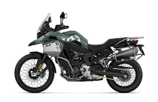 Ein grau-grünes BMW-Motorrad im Adventure-Stil, das schräg von der Seite vor einem weißen Hintergrund steht. Das Motorrad hat eine Camouflage-Lackierung, Speichenräder, einen Motorschutz und eine Gepäckhalterung am Heck.