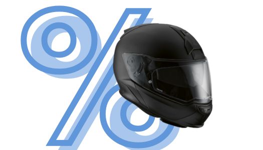 Zu sehen ist ein schwarzer Motorradhelm, der als Klapphelm konzipiert ist (ein sogenannter Systemhelm). Der Helm ist matt gehalten und hat eine moderne, aerodynamische Form mit einem großen, klaren Visier. Die Gesamterscheinung ist sehr schlicht und funktionell. Im Hintergrund überlagert ein großes, hellblau stilisiertes Prozentzeichen (%) das Produkt und den weißen Hintergrund, was auf ein Sonderangebot hindeutet.