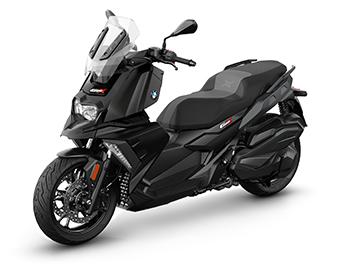 Das Bild zeigt den Scooter in einer Studioaufnahme vor neutralem weißem Hintergrund. Hier ist das Modell in einer komplett schwarzen Ausführung zu sehen, was dem Fahrzeug eine deutlich aggressivere und dezentere Optik verleiht. Ohne die farbigen Akzente kommen die kantigen Formen der Frontverkleidung und der markante LED-Scheinwerfer im typischen BMW-GS-Stil besonders gut zur Geltung. Man erkennt hier zudem sehr gut das Design der schwarzen Gussräder und die Scheibenbremsanlage am Vorderrad.