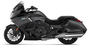  Ein dunkelgraues oder schwarzes Motorrad von BMW, schräg von der Seite fotografiert vor einem weißen Hintergrund. Der Name des Motorrads, K 1600 B, ist in großer, fetter schwarzer Schrift unter dem Bild zu sehen.