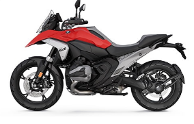  Ein rot-weißes Motorrad von BMW im Enduro-Stil, schräg von der Seite fotografiert vor einem weißen Hintergrund. Das Motorrad hat einen silberfarbenen Tank, rote Verkleidungsteile und Speichenfelgen. Es ist mit einer großen Windschutzscheibe und einem hohen Vorderradschutzblech ausgestattet.