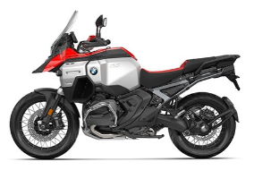 Ein rot-weißes Motorrad von BMW im Enduro-Stil, schräg von der Seite fotografiert vor einem weißen Hintergrund. Das Motorrad hat einen silberfarbenen Tank, rote Verkleidungsteile und Speichenfelgen. Es ist mit einer großen Windschutzscheibe und einem hohen Vorderradschutzblech ausgestattet.