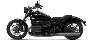  Ein großer, schwarzer BMW-Cruiser im Retro-Stil, der schräg von der Seite vor einem weißen Hintergrund steht. Er hat eine verchromte Auspuffanlage, ein breites Vorderrad, einen großen, runden Scheinwerfer und einen tiefliegenden Sitz.