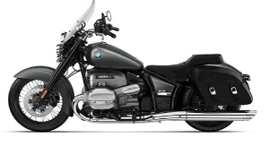  Ein graues BMW-Motorrad im Bagger-Stil, das schräg von der Seite vor einem weißen Hintergrund fotografiert ist. Es hat eine große Windschutzscheibe, seitliche Koffer, einen tief liegenden Sitz und verchromte Auspuffrohre auf der rechten Seite.