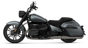  Ein Motorrad im Bagger-Stil von BMW, das in einem matten Grau gehalten ist. Es steht schräg von der Seite vor einem weißen Hintergrund. Das Motorrad hat einen breiten Lenker, seitliche Koffer, einen tief liegenden Sitz und verchromte Auspuffrohre auf der rechten Seite.